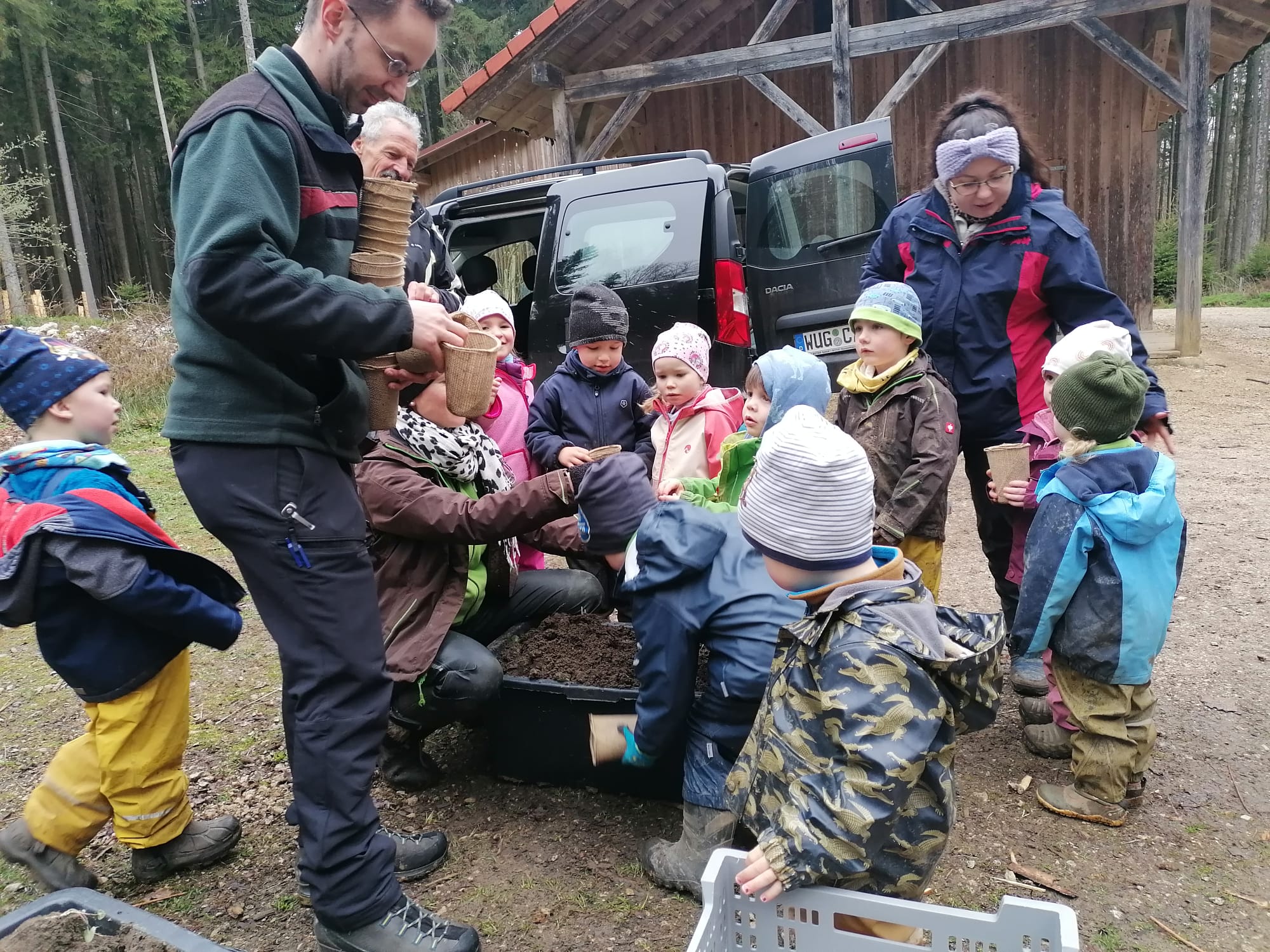 Die Waldkindergartenkinder mit ihren Erzieherinnen beim Säen der Eichen unter Anleitung von Forstamtsleiter Maximilian Plabst 